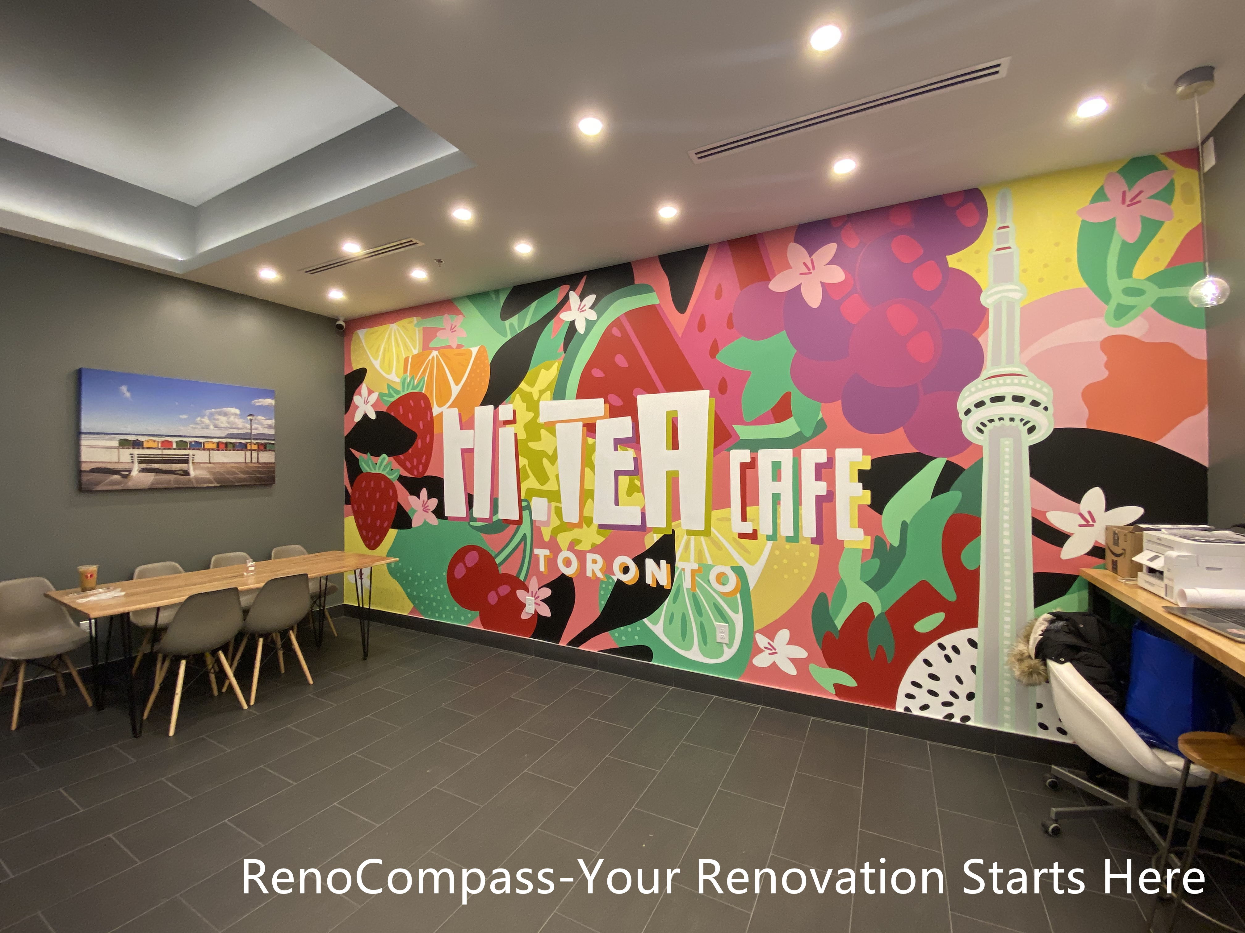 Restaurant renovation project in Toronto highlighting a custom-designed feature wall mural, modern dining area layout, recessed ceiling lighting, and durable tiled flooring. This commercial interior by Reno Compass Inc. blends brand identity with functional seating design, creating a vibrant and welcoming atmosphere for customers.