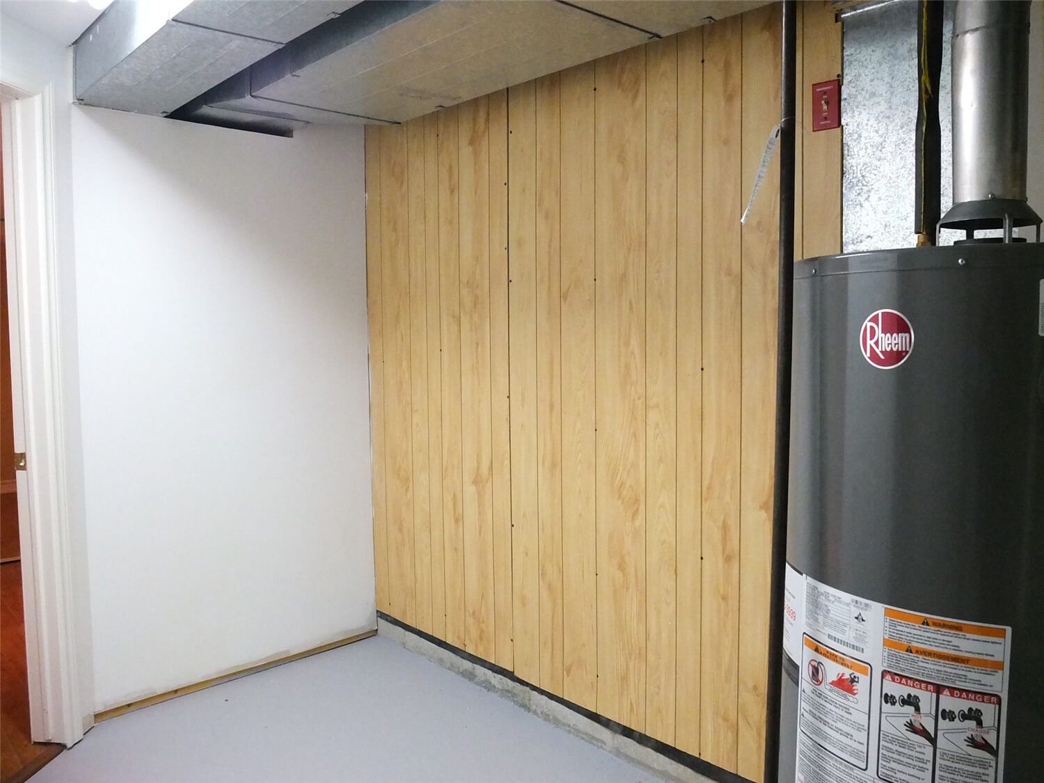 This Markham basement renovation includes improvements to the utility and mechanical room area. The project features newly finished wall panels, organized mechanical space, and protected installation around the water heater and ductwork. The clean wall finishing and structured layout help create a safer and more organized basement utility area while maintaining easy access for maintenance.
