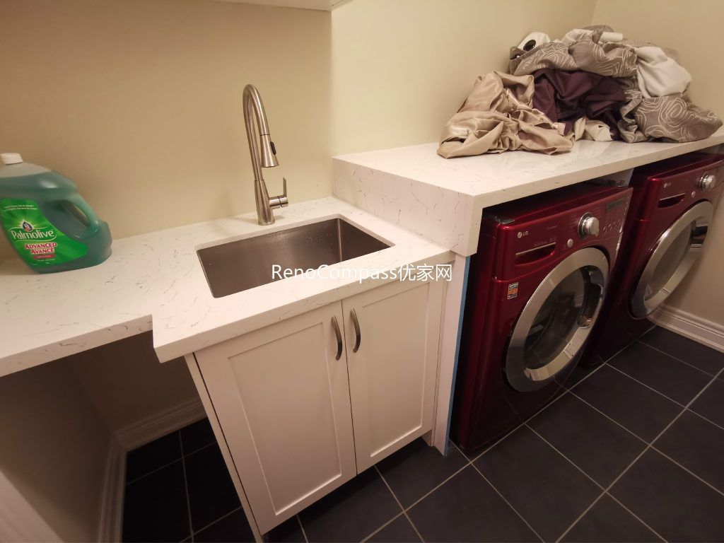This Richmond Hill basement renovation includes a functional laundry room with custom cabinetry, quartz countertop, and integrated utility sink for everyday convenience. Designed and completed by a professional Toronto renovation company, the upgraded laundry area improves storage, organization, and usability within the finished basement. Durable flooring, modern fixtures, and efficient layout planning create a clean and practical space that enhances overall basement functionality and home value.