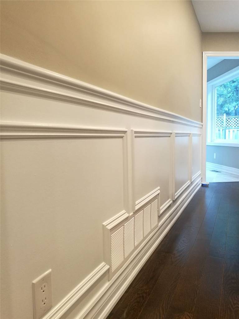 This Newmarket interior renovation features custom wall paneling and wainscoting with clean trim lines and precise detailing. Paired with dark hardwood flooring, the refined wall finish adds depth and elegance to the space, highlighting the craftsmanship and finish quality delivered by a professional Toronto renovation company.
