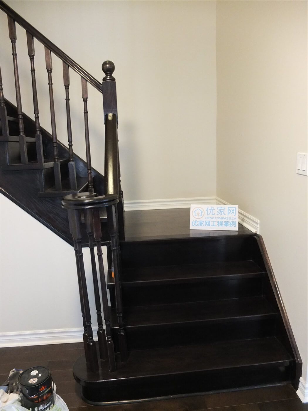 Dark hardwood staircase and flooring renovation in a Toronto home, featuring modern wood stair railing and matching hardwood floors as part of a professional interior renovation project by a Toronto renovation company.