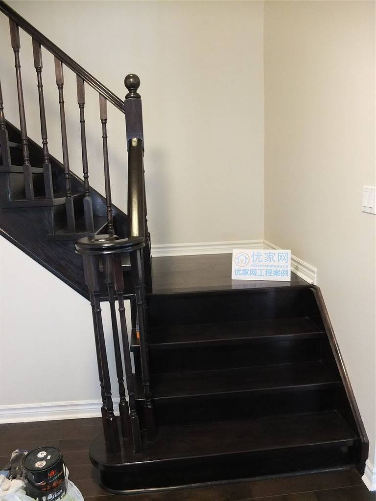 Dark hardwood staircase and flooring renovation in a Toronto home, featuring modern wood stair railing and matching hardwood floors as part of a professional interior renovation project by a Toronto renovation company.