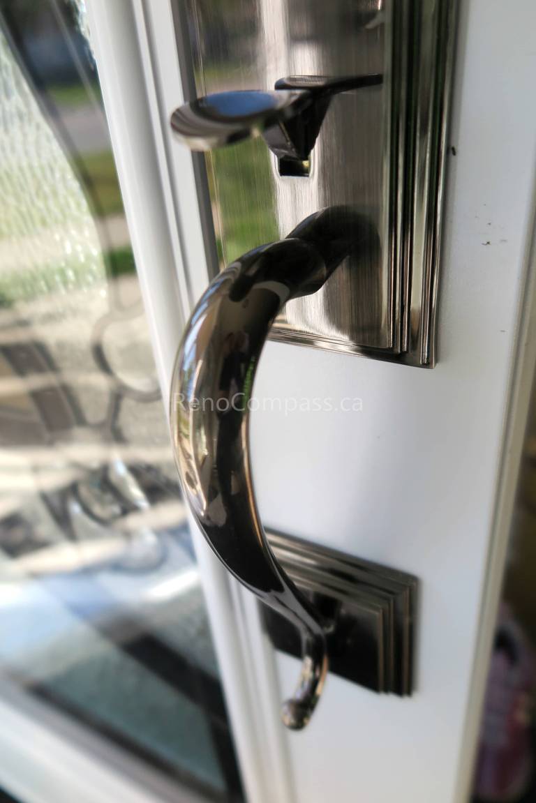 Close-up detail of newly installed double entry door hardware in a Newmarket home, featuring modern black handles and secure locking systems paired with decorative privacy glass panels. Completed by a professional Toronto Renovation Company, this door upgrade enhances both security and visual appeal while adding a refined, high-end finish to the home’s main entrance.
