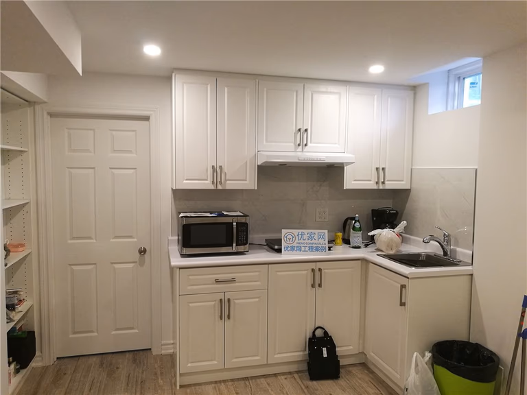 Basement kitchen renovation in Richmond Hill featuring white custom cabinetry, quartz countertop, modern backsplash, and recessed lighting. This interior renovation project was completed by a professional Toronto renovation company, focusing on functionality, clean layout, and long-term durability for rental or personal use.