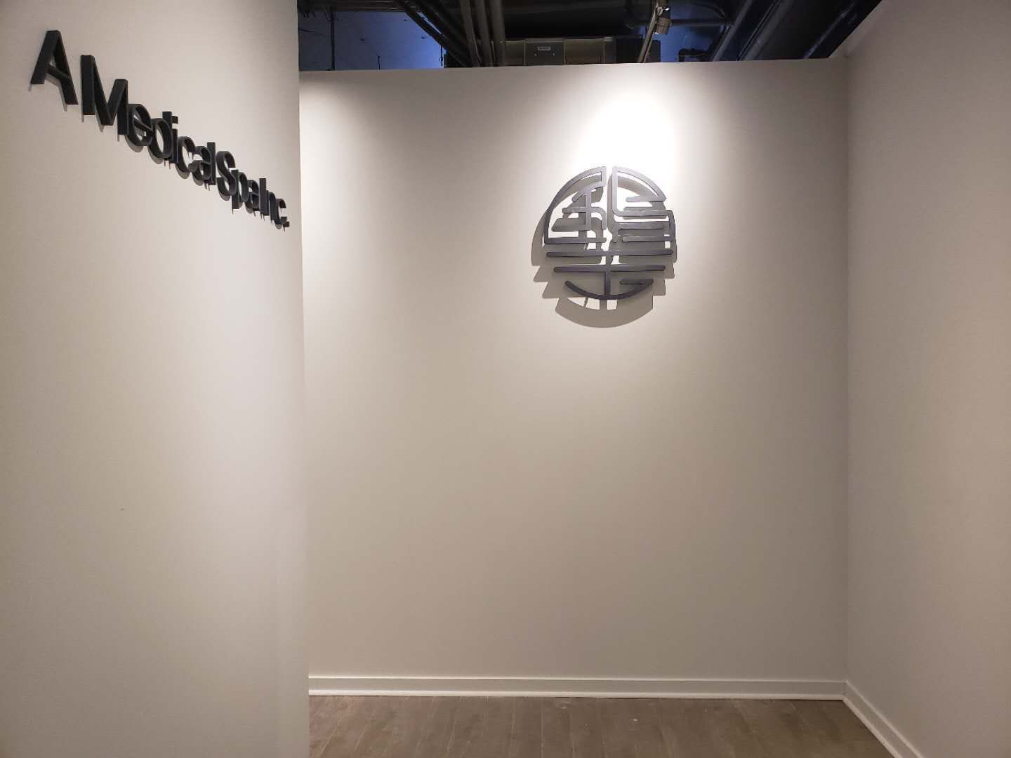This image showcases a custom wall art feature installed as part of a professional Toronto renovation company commercial interior renovation for a beauty and massage spa. The decorative wall piece is carefully positioned with accent lighting to create a calm, refined, and welcoming atmosphere, enhancing brand identity and customer experience. The design reflects attention to detail, spatial balance, and lighting coordination, which are essential in spa and wellness commercial renovations. Ideal for massage clinics, beauty spas, and wellness centers seeking a modern and tranquil interior upgrade in Toronto.