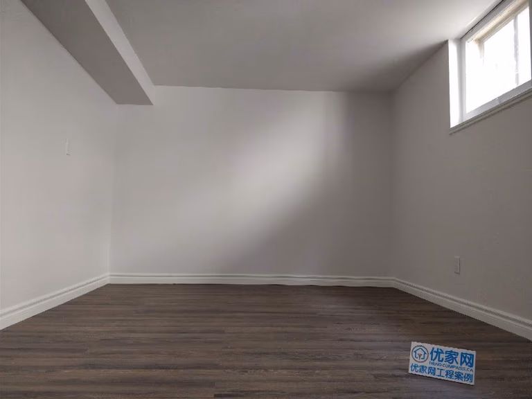 This Scarborough basement renovation features a clean and modern finished living space with durable vinyl flooring, smooth painted walls, and upgraded baseboards. A high basement window allows natural light to brighten the room, creating a comfortable and functional area suitable for a recreation room, home office, or additional living space. Completed with attention to detail, this basement upgrade improves both usability and property value for the homeowner.