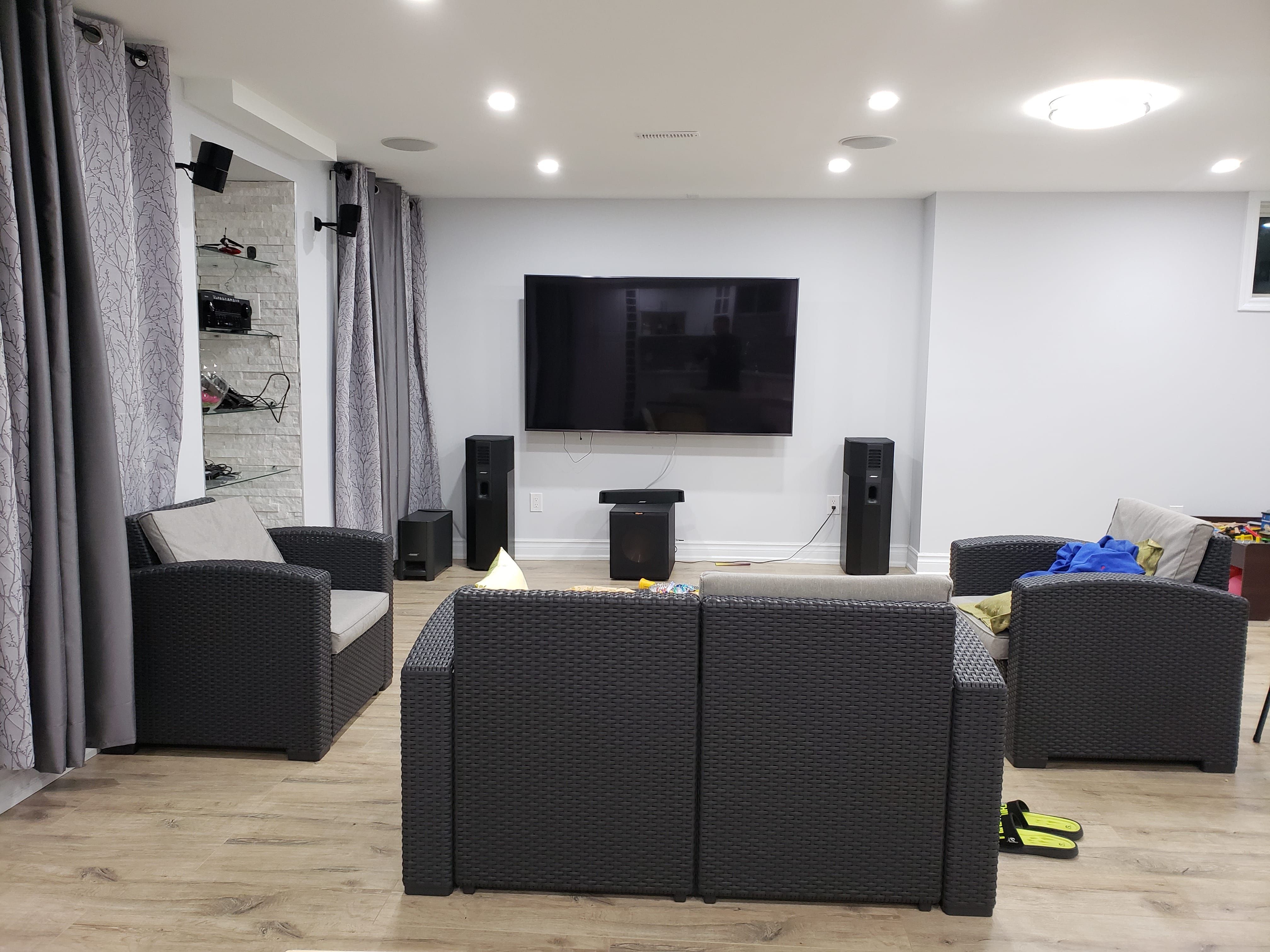 This finished basement renovation in Newmarket, Toronto showcases a modern entertainment and media area designed for comfort and functionality. The space features upgraded flooring, recessed pot lights, and a wall-mounted large screen TV with a full home theater speaker setup. Custom built-in shelving with glass accents adds storage and display functionality, while neutral wall tones and layered lighting create a clean, contemporary feel. The open-concept layout allows for a comfortable lounge and family gathering space, making the basement ideal for movie nights and daily living. Completed by a professional Toronto renovation company, this project highlights practical design, durability, and modern basement living.