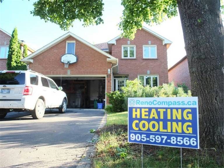 Professional outdoor air conditioner condenser installation by Reno Compass in Toronto. This energy-efficient HVAC unit is securely mounted on a raised stand with proper drainage and ventilation clearance, ensuring optimal cooling performance, durability, and safe operation for residential homes. Installed by licensed technicians for long-term reliability and comfort.