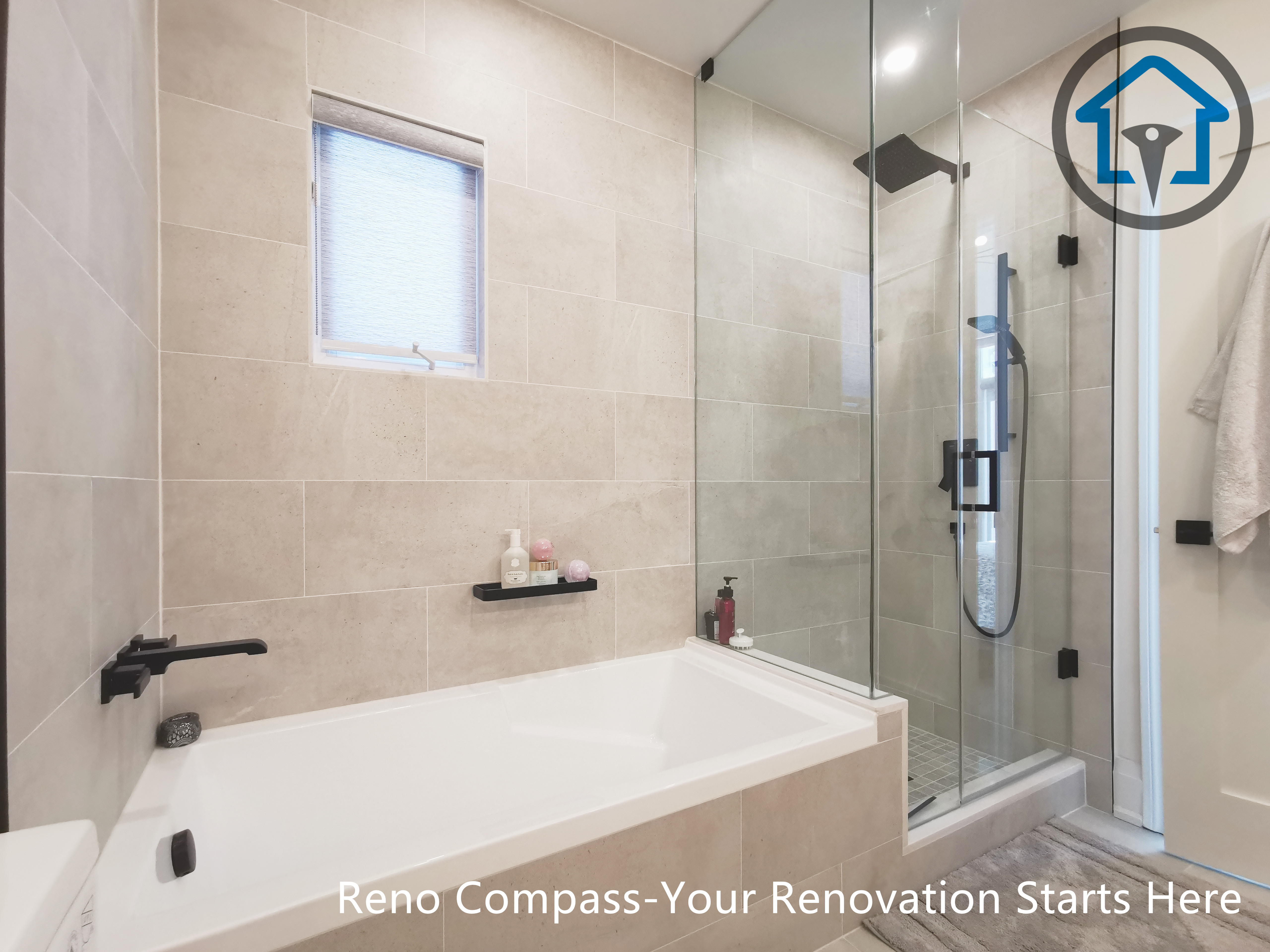 This North York bathroom renovation features a modern bathtub paired with a glass-enclosed shower and large-format wall tiles. Matte black fixtures provide a clean contrast against the neutral tile palette, while the window brings in natural light to enhance comfort and brightness. Completed by a Toronto renovation company focused on durable materials and refined bathroom design.