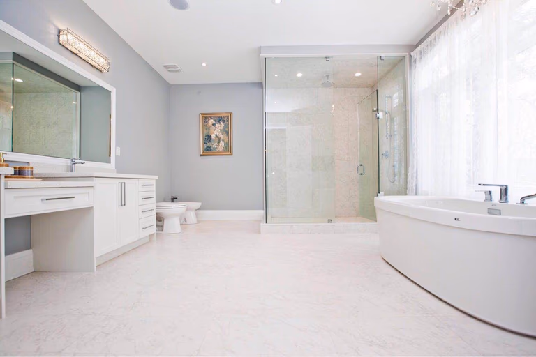 Modern luxury bathroom completed as part of a Toronto design build custom build project, featuring a spacious double vanity, quartz countertops, large mirror, and clean contemporary finishes. This whole house renovation Toronto project highlights the elegant bathroom design and functional layout commonly found in luxury custom homes across Toronto.