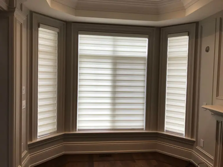 Custom zebra blinds installation in Toronto dining room by professional Toronto renovation company Reno Compass Inc. Featuring dual-layer light filtering shades, clean white window trim, modern chandelier lighting, and elegant wall panel detailing. This window treatment upgrade enhances privacy, natural light control, and interior aesthetics with a sleek and contemporary finish.