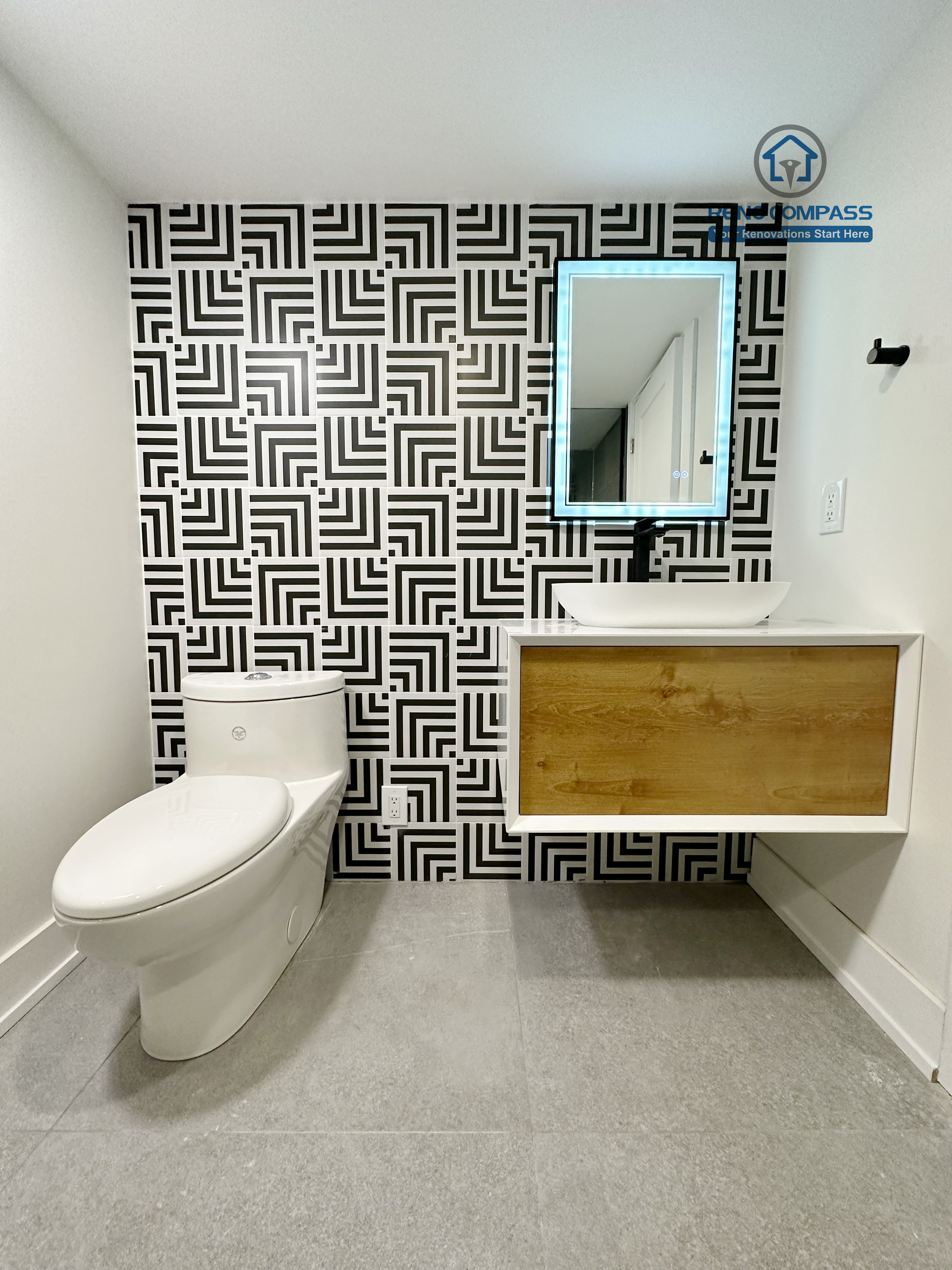 Contemporary bathroom renovation in Richmond Hill featuring a floating wood-accent vanity, modern vessel sink, matte black fixtures, and vertical tile backsplash for a clean and stylish bathroom design.
