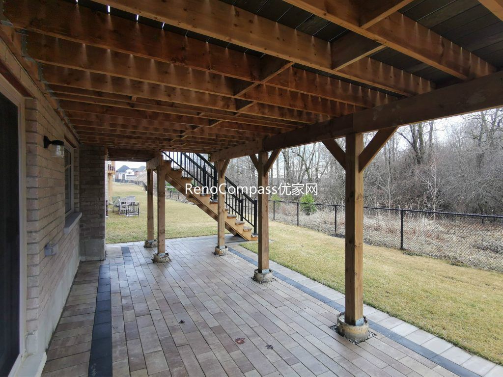 Professional interlocking patio installation in Aurora featuring durable stone pavers and clean border detailing beneath an elevated deck. This custom outdoor renovation improves drainage, usability, and backyard aesthetics while creating a functional covered patio space for all-season outdoor living.