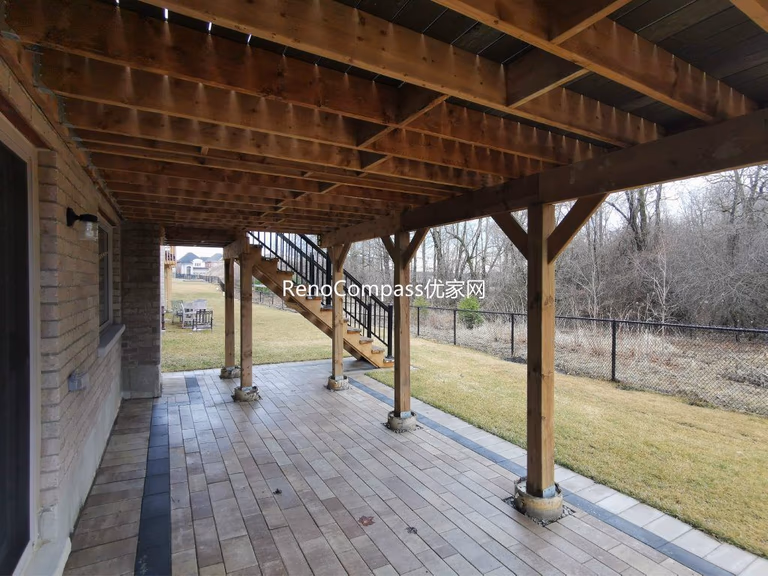Professional interlocking patio installation in Aurora featuring durable stone pavers and clean border detailing beneath an elevated deck. This custom outdoor renovation improves drainage, usability, and backyard aesthetics while creating a functional covered patio space for all-season outdoor living.