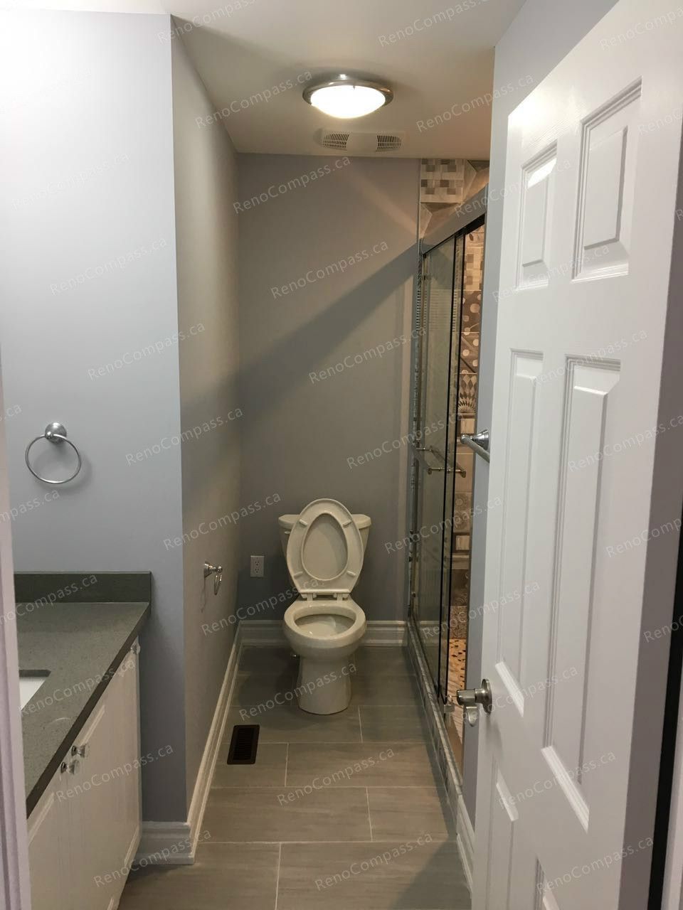 This Markham interior renovation highlights a modern bathroom upgrade featuring a glass-enclosed shower, contemporary vanity, and durable tile flooring. Neutral wall tones and updated lighting create a clean, functional space with improved comfort and usability. Completed by an experienced Toronto renovation company, the bathroom was redesigned to combine practicality with a sleek, modern finish.