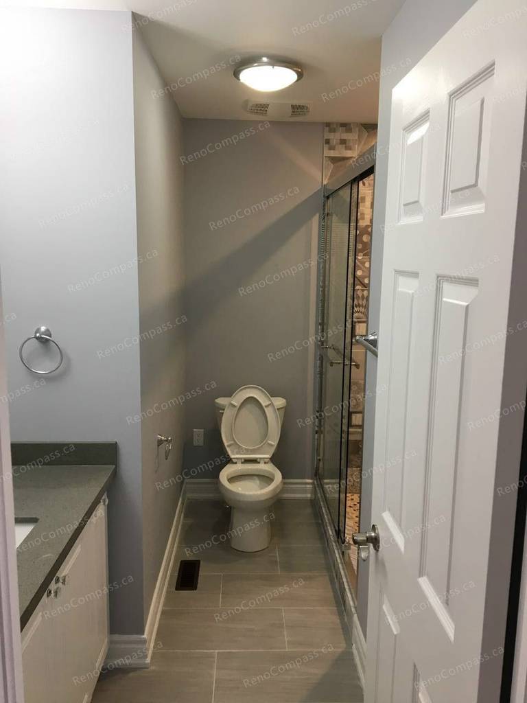 This Markham interior renovation highlights a modern bathroom upgrade featuring a glass-enclosed shower, contemporary vanity, and durable tile flooring. Neutral wall tones and updated lighting create a clean, functional space with improved comfort and usability. Completed by an experienced Toronto renovation company, the bathroom was redesigned to combine practicality with a sleek, modern finish.