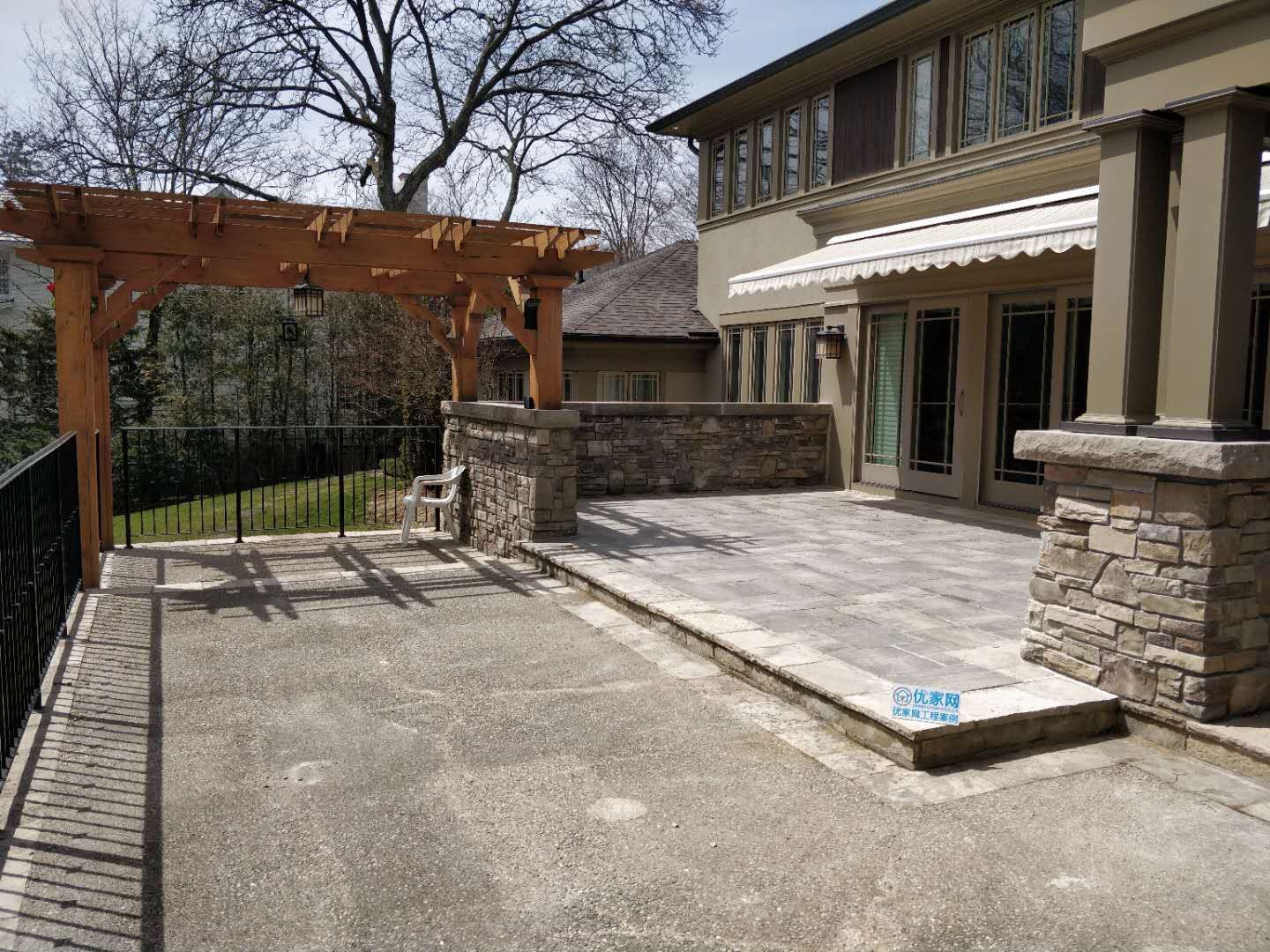 Oakville backyard renovation featuring a spacious interlock stone patio, custom pergola, and stone column detailing. Designed to create a durable, low-maintenance outdoor living and entertaining area.