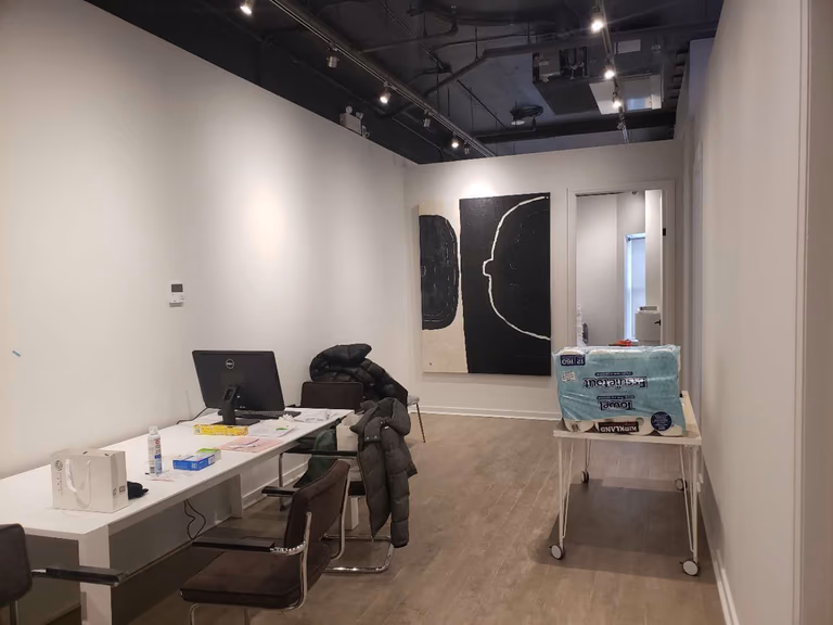 This image highlights the reception and consultation area of a modern beauty and massage spa, completed by a professional Toronto renovation company specializing in commercial interior renovations. The space features clean wall finishes, wood-look flooring, and an open ceiling concept with track lighting to create a contemporary and welcoming environment. Functional workspace planning allows for efficient client check-in, consultation, and daily operations. The minimalist layout and neutral tones enhance the overall calm and professional atmosphere, making it ideal for spa, wellness, and beauty clinic interiors across Toronto and the GTA.