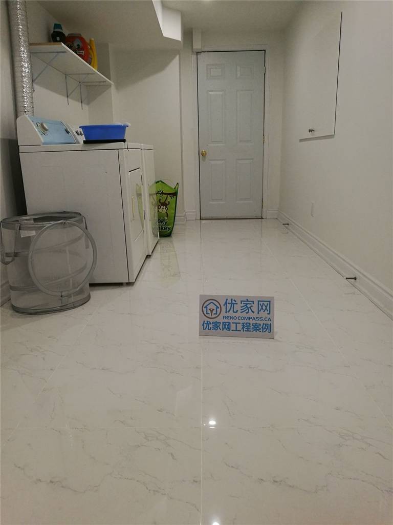 This image highlights a clean and functional laundry and utility area completed during a Vaughan basement renovation project. Designed for practicality and durability, the space features easy-maintenance floor tiles, bright lighting, and a well-organized layout that accommodates washer, dryer, and storage shelving. The open floor area allows for comfortable movement while maintaining a neat and efficient workflow.

Careful finishing around the ceiling bulkhead, walls, and trim ensures a polished and cohesive appearance that integrates seamlessly with the rest of the finished basement. Completed by an experienced Toronto Renovation Company, this basement laundry upgrade improves daily convenience while adding long-term usability and value to the home.