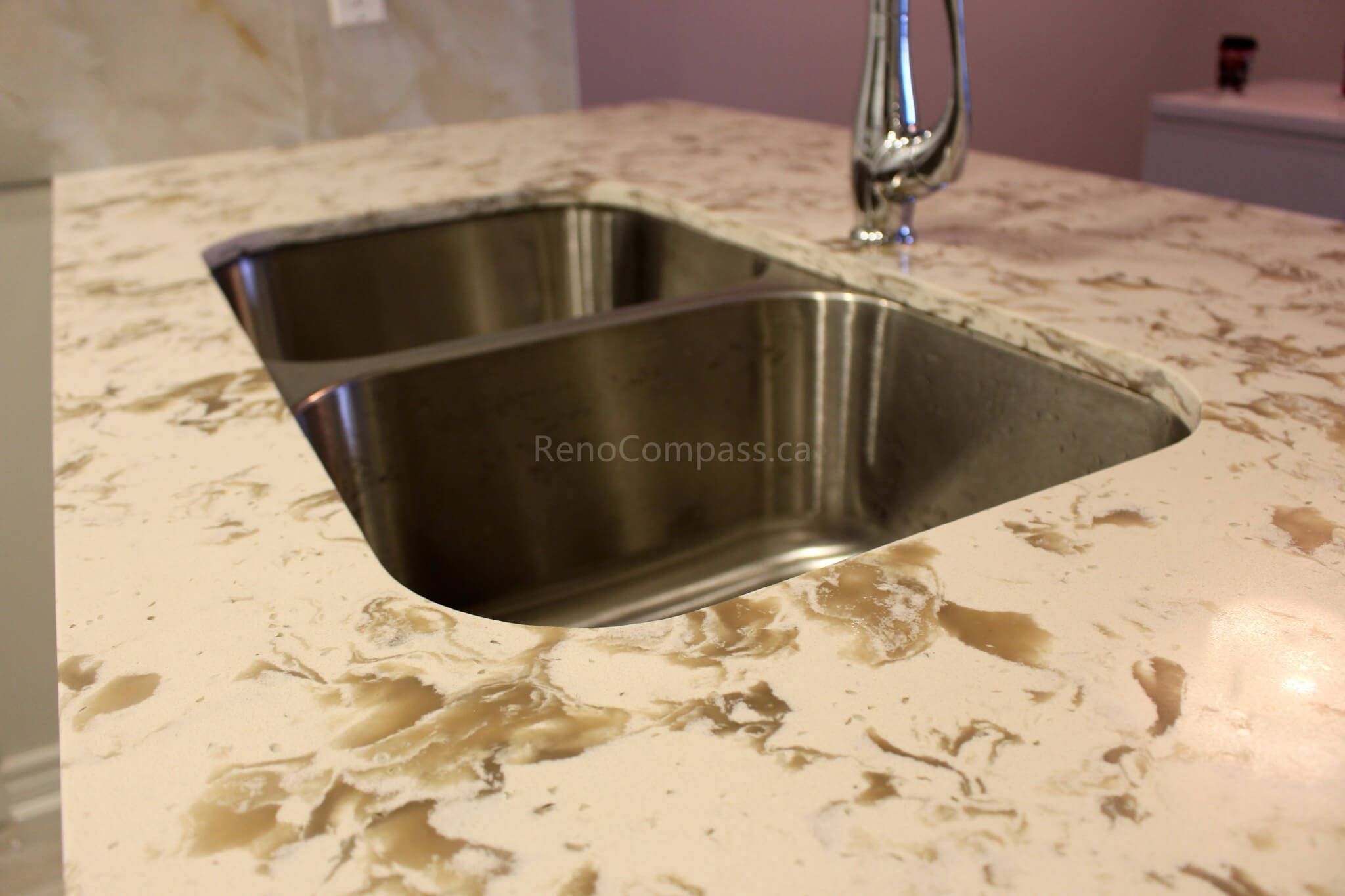 Close-up view of a beautifully designed quartz countertop featuring a deep double stainless steel sink and a modern chrome faucet. This Mississauga kitchen renovation showcases premium materials and a sleek, functional design for contemporary living.