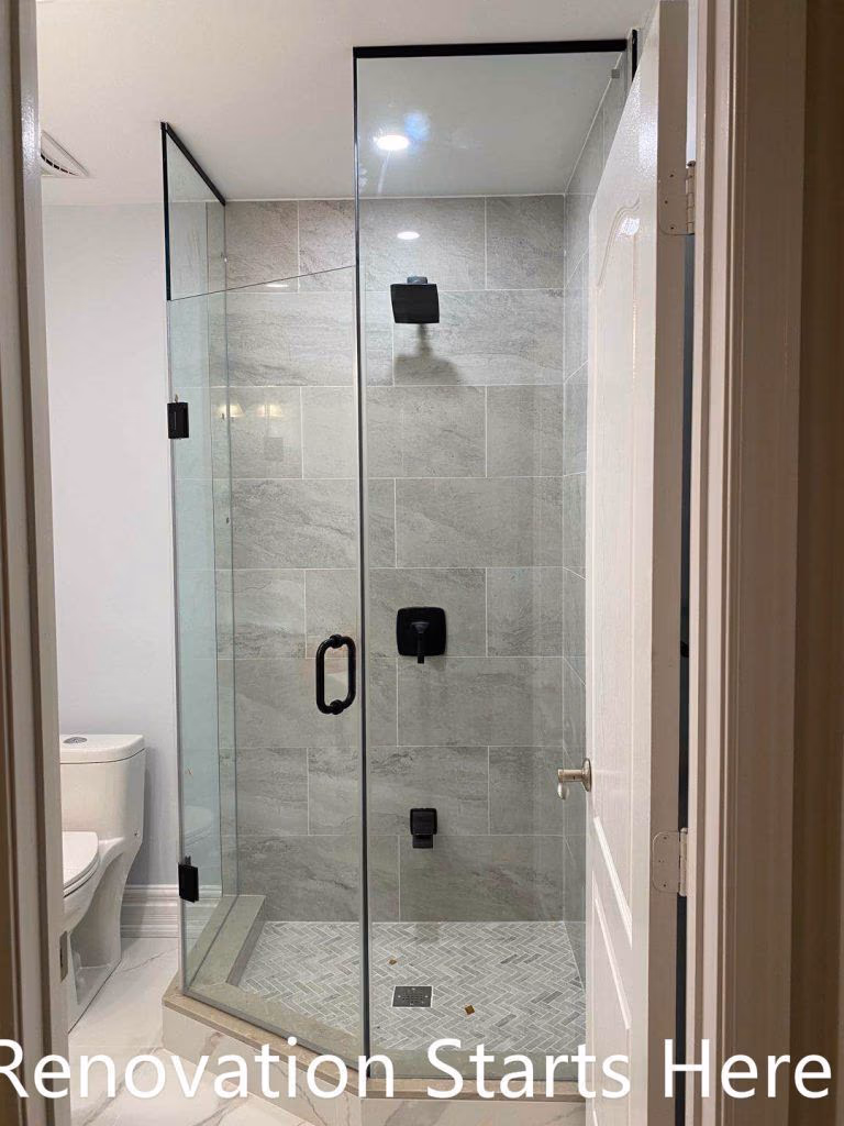 This Thornhill bathroom renovation features a compact walk-in shower enclosed with frameless glass, maximizing visual openness within a narrow layout. Large-format gray wall tiles combined with a herringbone-patterned shower base add texture and depth, while matte black shower fixtures provide a modern, cohesive finish. The clean layout and glass enclosure improve brightness, circulation, and daily functionality, making the space well-suited for guest or secondary bathroom use.