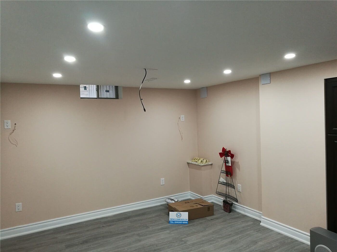 This image shows a completed basement living area from a Newmarket interior renovation project. The space features upgraded flooring, smooth drywall finishes, and recessed pot lighting that provides even illumination throughout the room. Neutral wall tones and a clean ceiling design create a bright, open atmosphere suitable for a family room, home office, or recreational space. Completed by a professional Toronto renovation company, this basement renovation enhances comfort, functionality, and long-term property value.