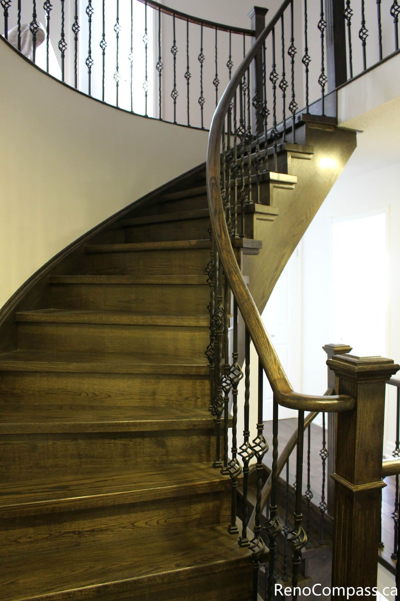This Mississauga interior renovation features a beautifully crafted curved hardwood staircase with custom iron balusters and rich wood detailing. The spiral design enhances architectural flow while adding a dramatic and elegant focal point to the home. Completed by a professional Toronto renovation company, Reno Compass Inc., this project highlights precision carpentry, premium materials, and refined interior craftsmanship.