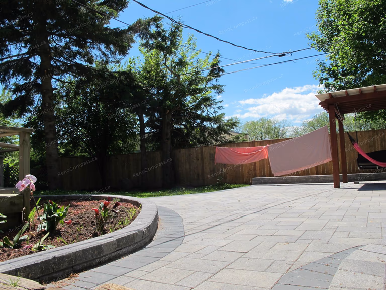 This Markham outdoor landscaping project showcases a beautifully designed interlock patio with curved stone borders and a custom garden bed layout. The spacious paved backyard provides a clean, modern outdoor living area perfect for relaxation and gatherings. Surrounded by mature trees and enhanced with professional garden design, this renovation highlights Reno Compass Inc.’s expertise in backyard transformation, combining durable interlock installation with elegant landscaping to create a functional and visually appealing outdoor space.