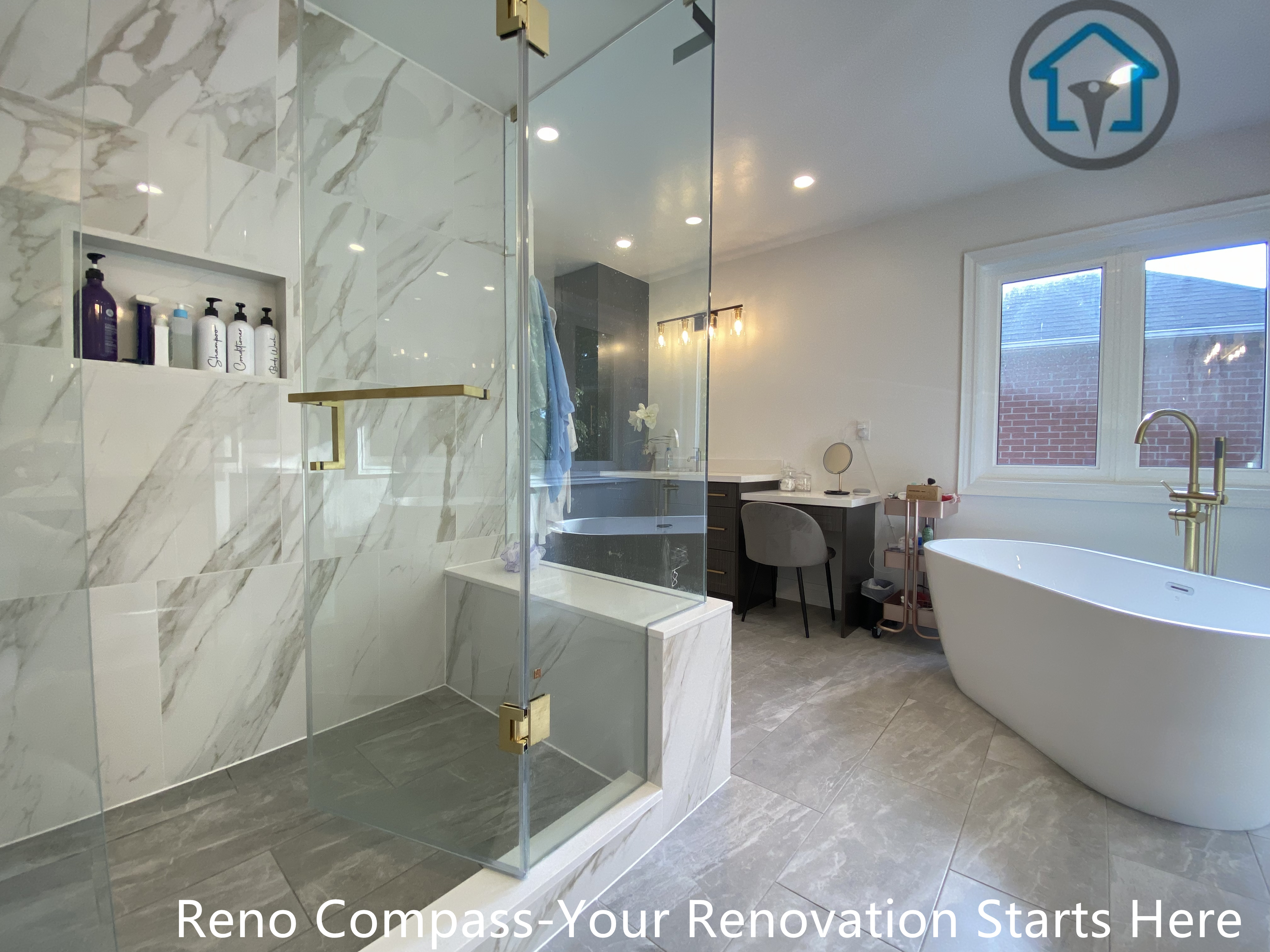 This modern master bathroom features a frameless glass walk-in shower, marble-look wall tiles, a freestanding bathtub, and warm brass fixtures, creating a bright and spa-inspired space.