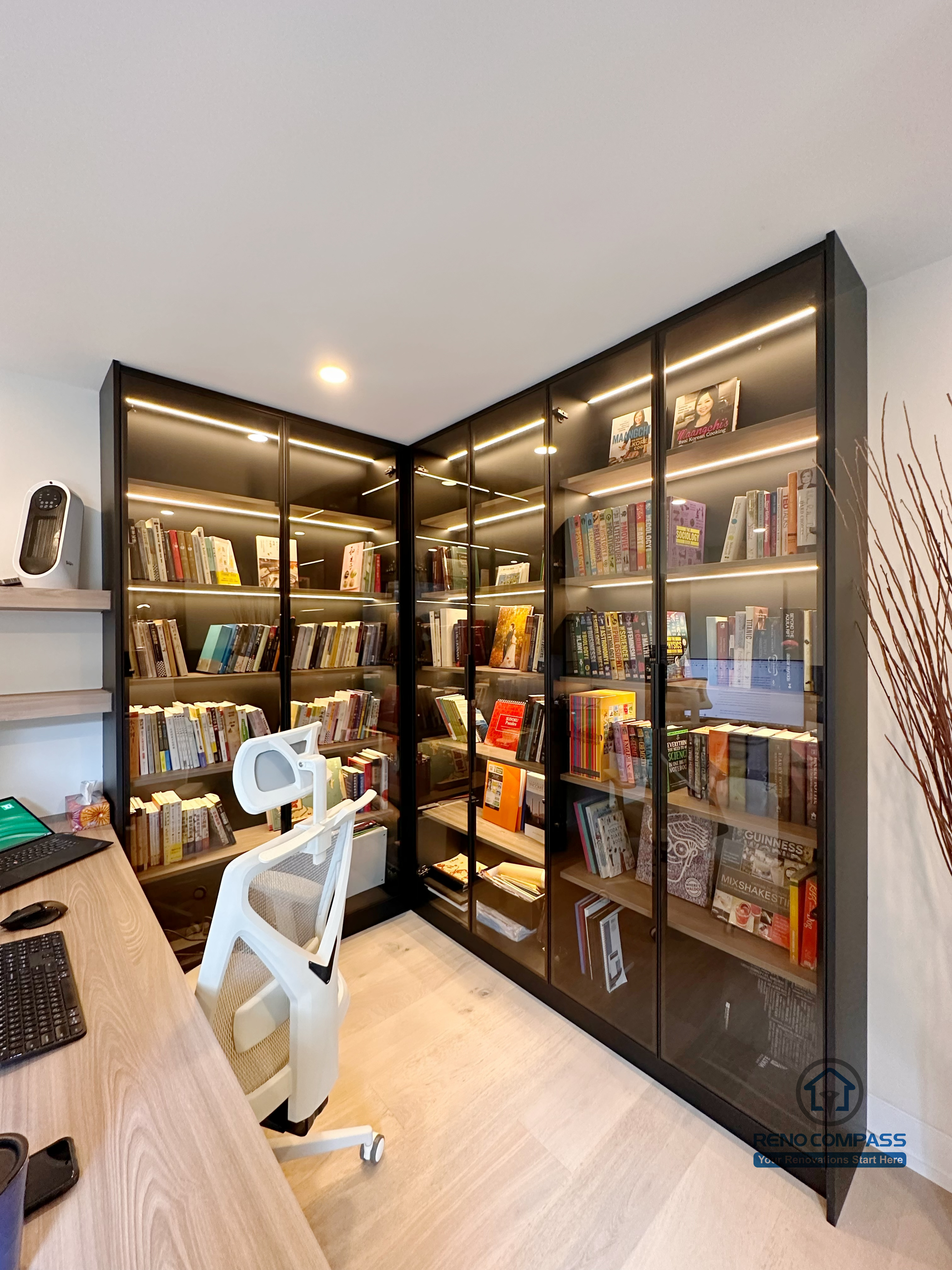 A custom-built home office and library cabinetry project in Toronto featuring floor-to-ceiling glass display bookcases with integrated LED lighting. This tailored storage solution blends workspace functionality with elegant custom cabinetry design, highlighting craftsmanship and space optimization by a professional Toronto renovation company.