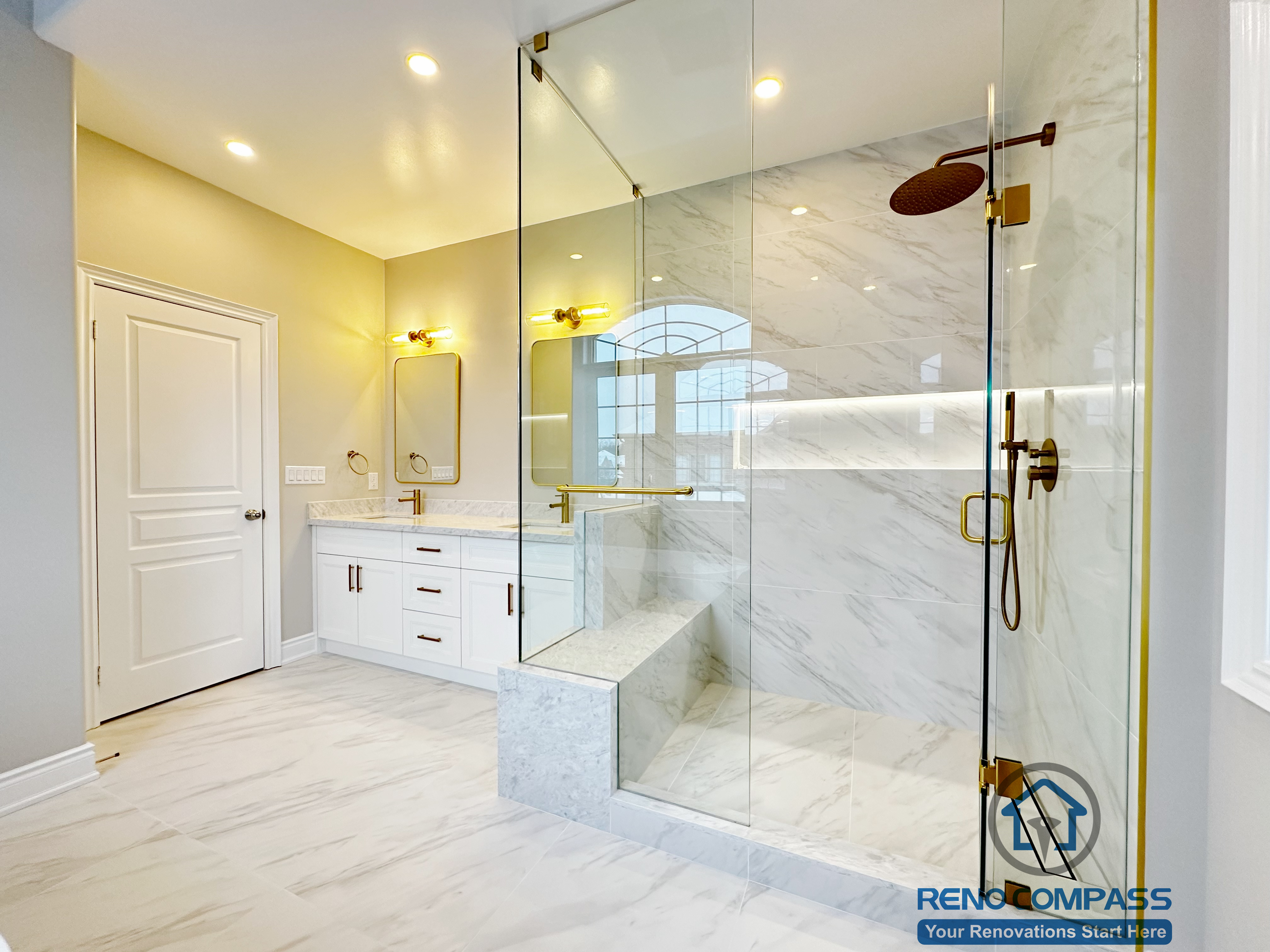 Bright and modern primary bathroom renovation in Vaughan featuring a frameless glass walk-in shower, marble-look porcelain tiles, dual vanity with gold fixtures, and custom shower bench. Designed and completed by a professional Toronto renovation company with attention to layout, lighting, and luxury finishes.