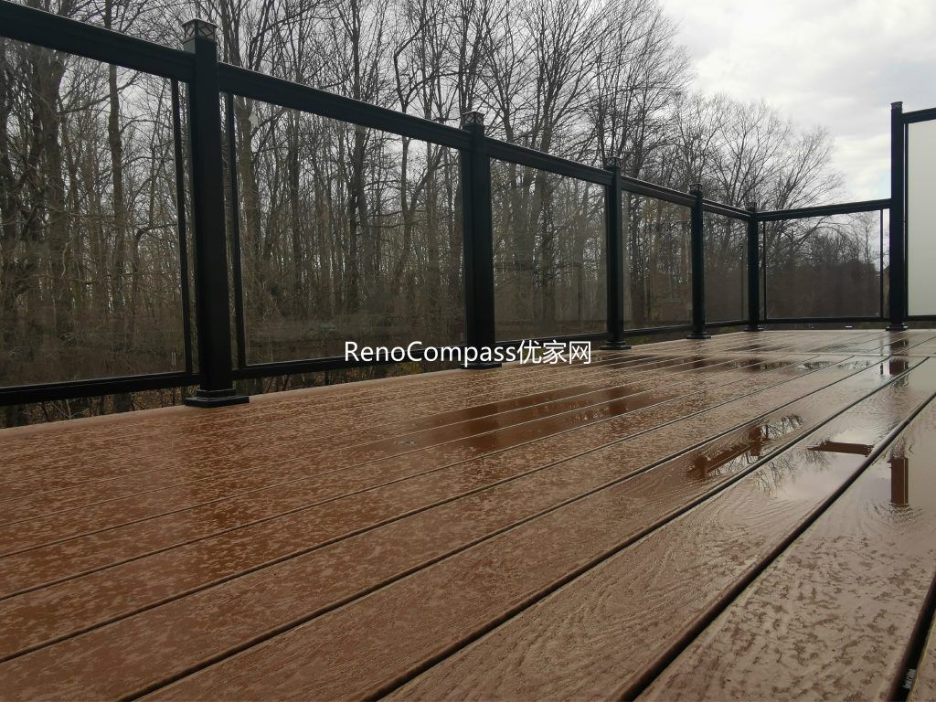 Modern backyard deck renovation project in Aurora featuring durable composite deck flooring, black aluminum and frosted glass privacy railings, and professional interlocking installation. This outdoor renovation enhances privacy, safety, and visual appeal while creating a functional and stylish outdoor living space for homeowners.