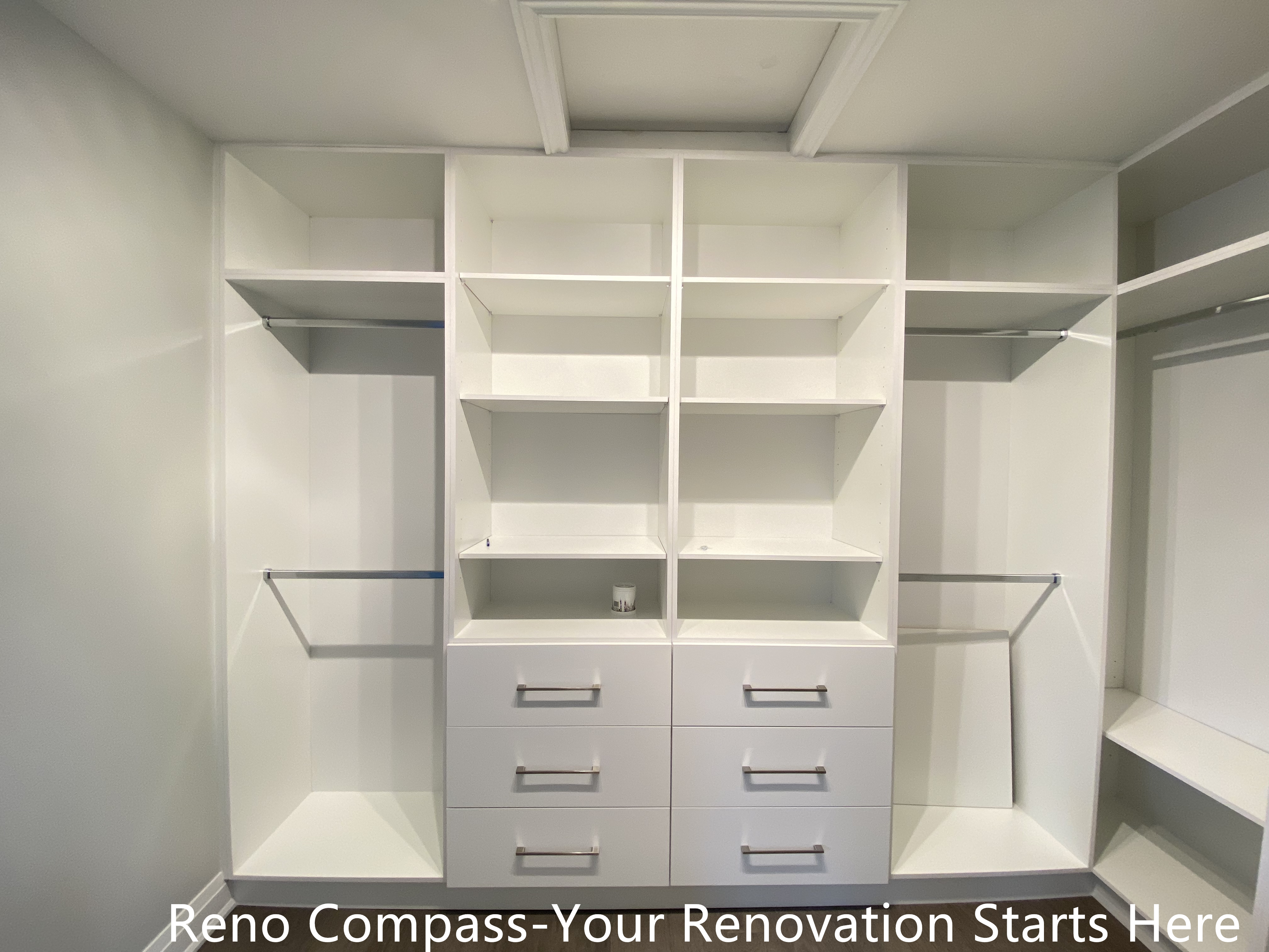 Custom walk-in closet featured in an Oakville interior renovation, showcasing built-in shelving, hanging rods, and integrated drawer storage for optimal organization. The clean white cabinetry and functional layout provide a modern storage solution designed and completed by a professional Toronto renovation company.