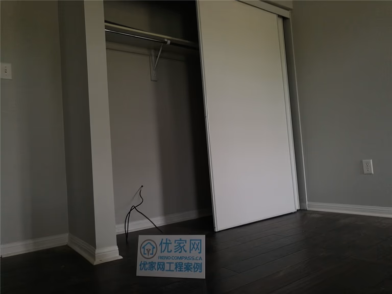 This image showcases the newly installed dark hardwood flooring extending seamlessly into the bedroom closet area in this Scarborough flooring replacement project. The clean transitions, precise baseboard finishing, and smooth plank alignment reflect professional craftsmanship. Completed by a trusted Toronto Renovation Company, the installation ensures durability, structural stability, and a polished modern look throughout the space.