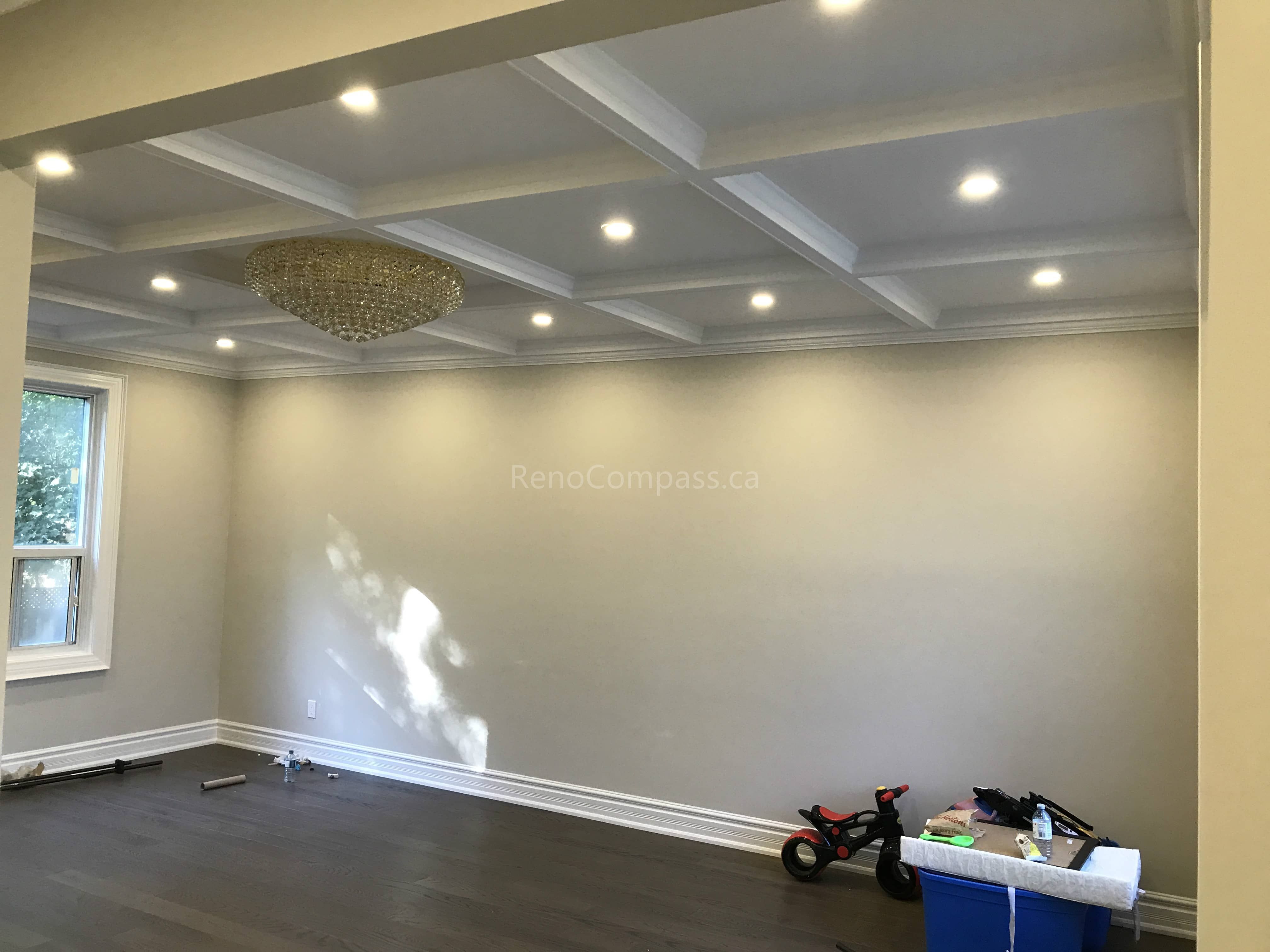This Toronto basement renovation features a beautifully finished coffered ceiling with recessed pot lights, modern flooring, and upgraded trim work. The bright and open layout enhances ceiling depth and lighting, creating a refined and comfortable living space for family use or entertainment. Completed by Reno Compass, a professional Toronto renovation company, this project highlights detailed craftsmanship and elegant basement interior design.