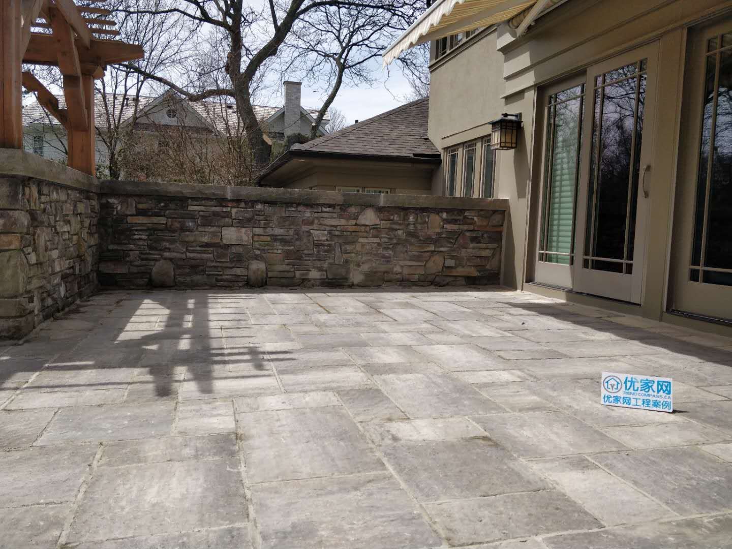 Oakville backyard renovation featuring a spacious interlock stone patio, custom pergola, and stone column detailing. Designed to create a durable, low-maintenance outdoor living and entertaining area.