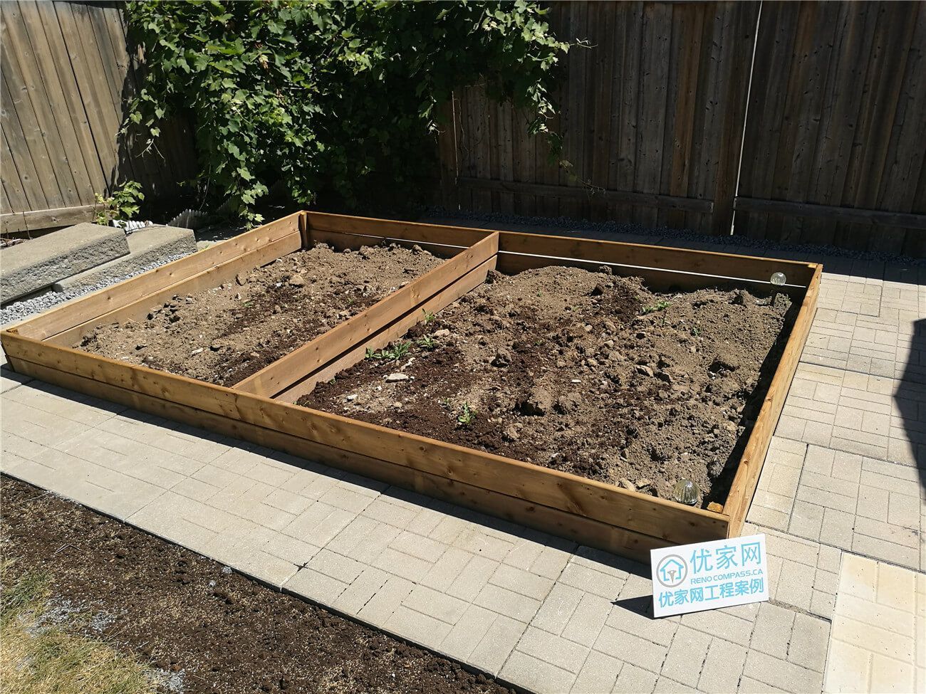 This Vaughan landscaping renovation features a custom-built wooden raised garden bed designed to add structure and functionality to the backyard. Framed with durable pressure-treated lumber and neatly positioned over a newly installed interlocking patio, the garden boxes create a defined planting area while maintaining a clean, organized layout. Completed by Reno Compass Inc., this project highlights precise carpentry, practical outdoor design, and a seamless integration between hardscape and softscape elements.