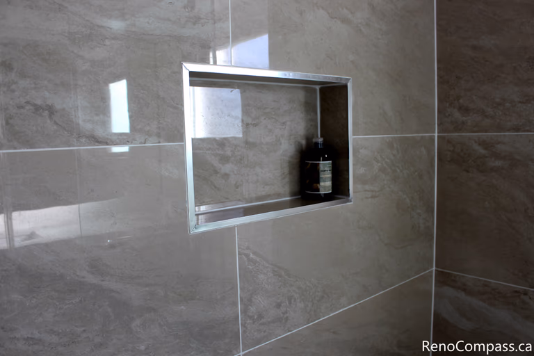 This Mississauga bathroom renovation captures the complete shower and bathroom layout, combining glass panels, tiled surfaces, and modern fixtures. The cohesive design balances functionality, comfort, and contemporary style.