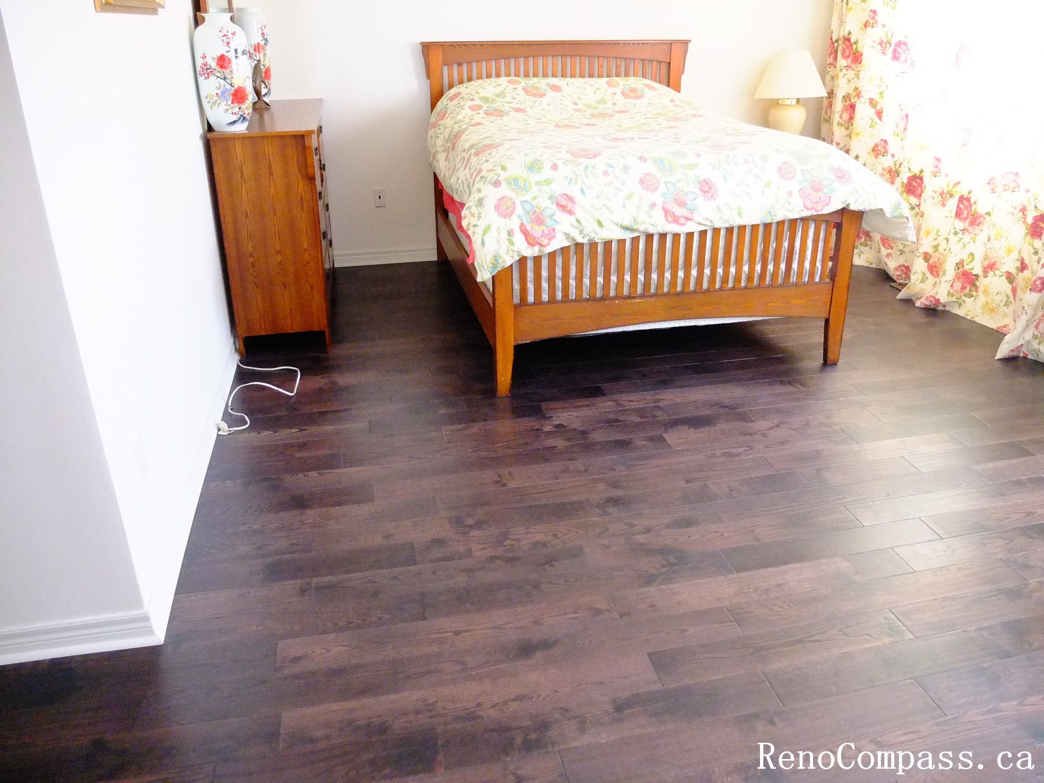Professional hardwood flooring installation in Toronto bedroom, featuring rich dark wood flooring that enhances warmth and elegance. This flooring upgrade improves durability, comfort, and overall home value, completed by Reno Compass renovation team.