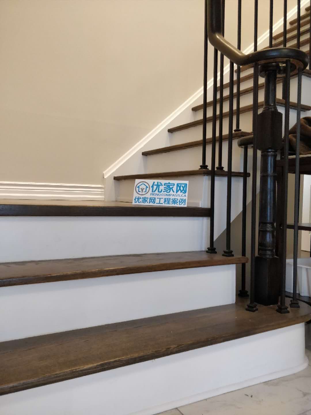 This staircase detail is part of a North York interior renovation, highlighting solid hardwood stair treads paired with black iron balusters and a matching handrail system. Clean white risers contrast with the wood tones to create a refined and durable stair design. Attention is given to step consistency, railing alignment, and safety standards for everyday use. Completed by a Toronto renovation company, this stair renovation emphasizes craftsmanship, material balance, and long-term structural quality.