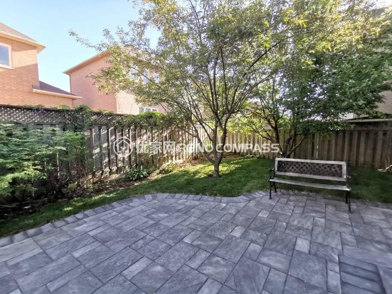 Beautiful backyard interlocking project in Richmond Hill featuring modern stone pavers, elegant tree landscaping, and a sitting bench — blending functionality and natural beauty for a relaxing outdoor space.
