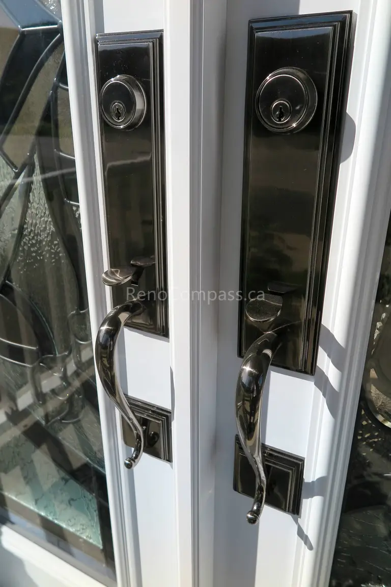Close-up detail of newly installed double entry door hardware in a New market home, featuring modern black handles and secure locking systems paired with decorative privacy glass panels. Completed by a professional Toronto Renovation Company, this door upgrade enhances both security and visual appeal while adding a refined, high-end finish to the home’s main entrance.