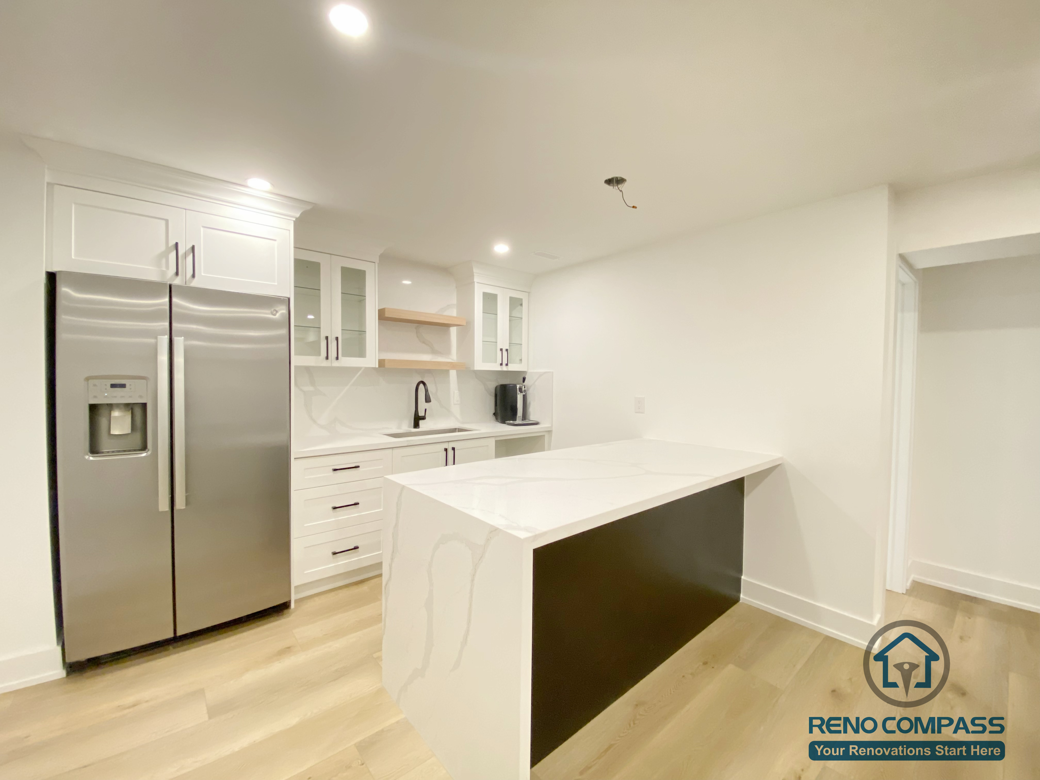 This modern basement kitchen includes a functional island layout, clean cabinetry, and efficient lighting. Designed to support entertaining and everyday use, the space seamlessly connects with the surrounding basement living areas.
