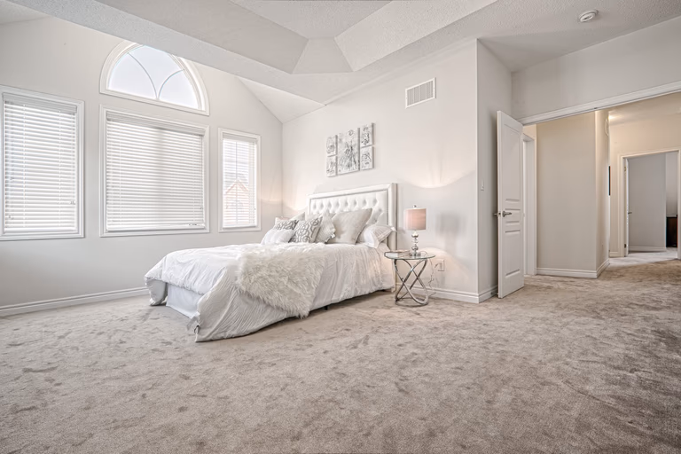 This Toronto luxury master bedroom renovation features a spacious layout with high ceilings, large arched windows, and soft neutral finishes that create a bright and relaxing atmosphere. The design includes premium carpeting, elegant lighting fixtures, and a functional layout that enhances comfort and everyday living. Completed by a professional Toronto renovation company, this bedroom interior project showcases quality craftsmanship, modern design, and timeless residential elegance tailored for contemporary homes.