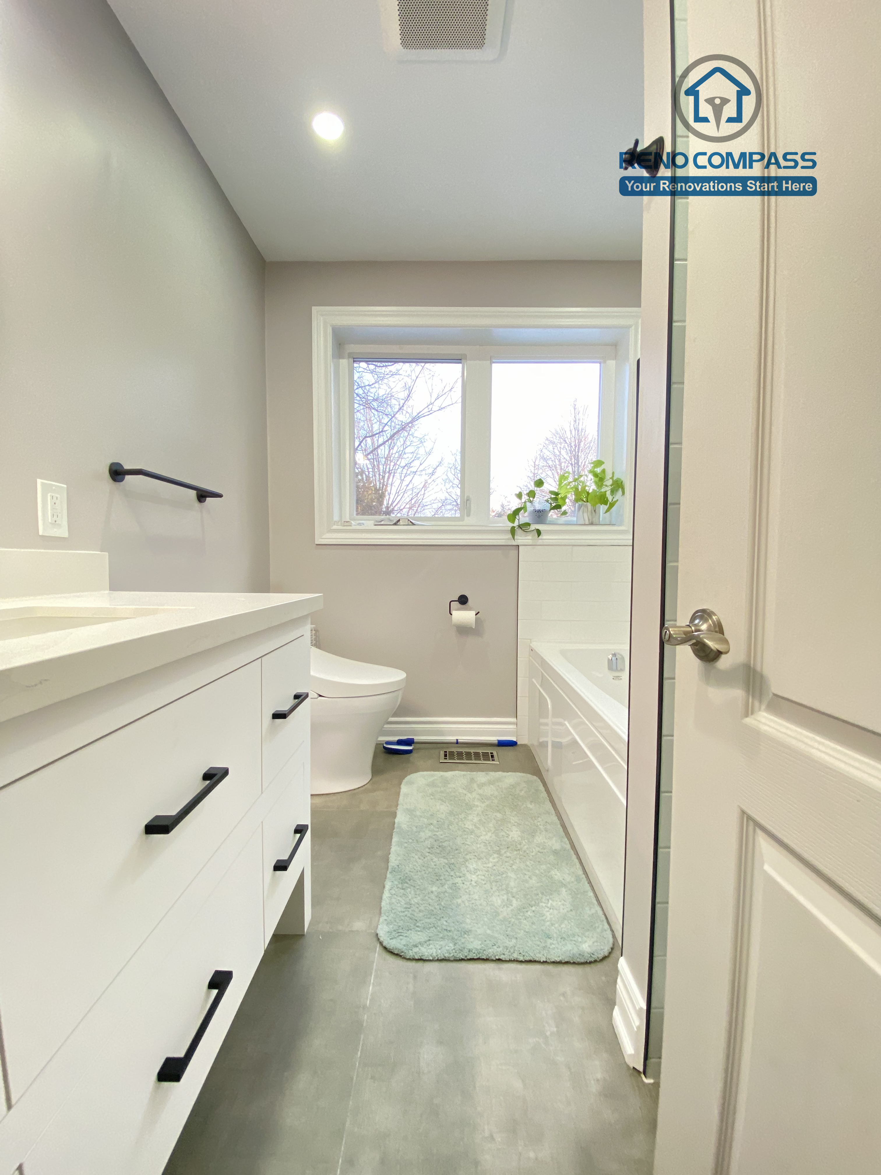 This North York bathroom renovation features a modern white vanity with a quartz countertop, matte black hardware, and a clean, functional layout. The neutral wall color, large-format floor tiles, and integrated lighting create a bright and timeless bathroom design, completed by a Toronto renovation company focused on quality craftsmanship and everyday usability.