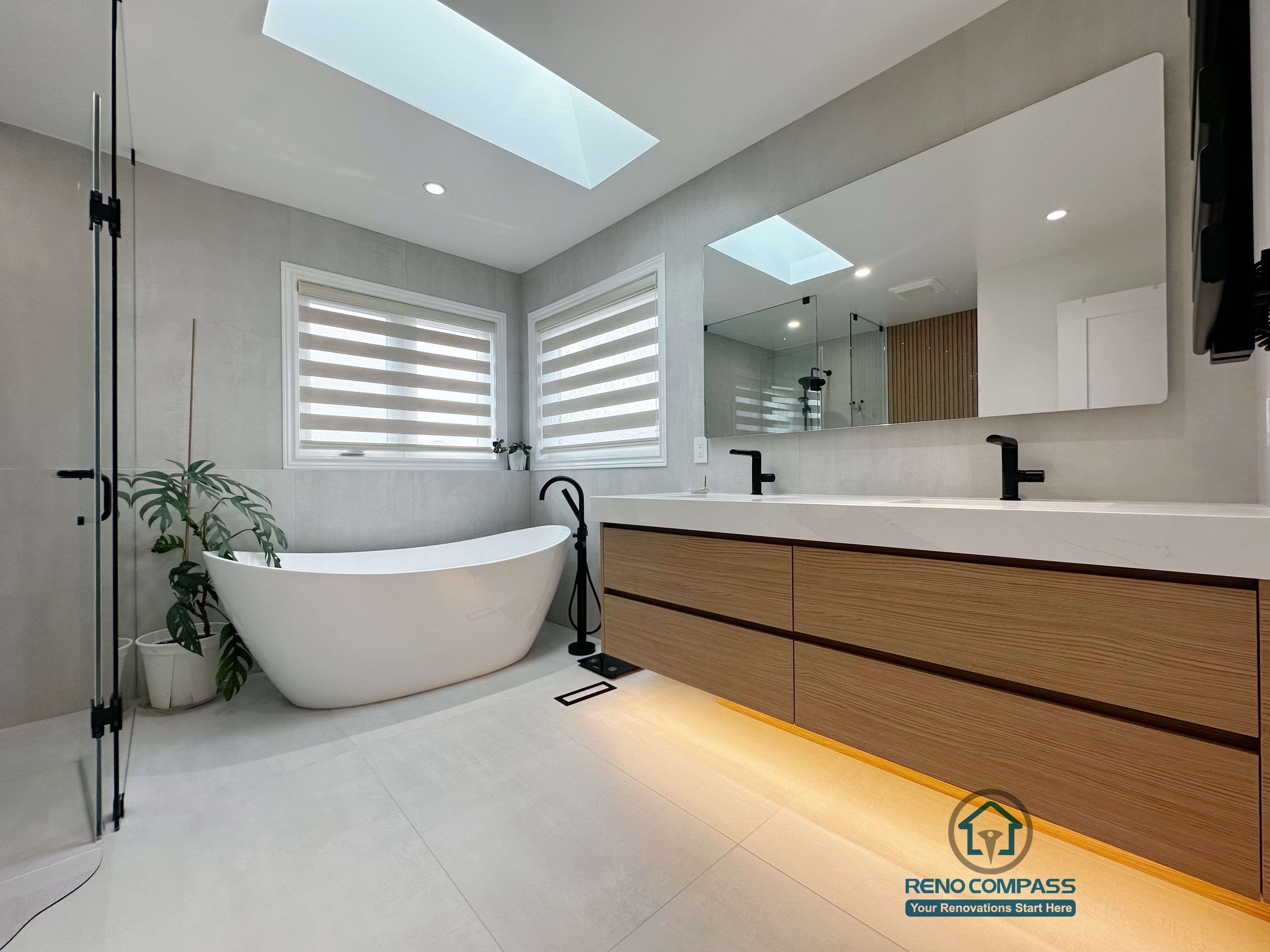 A modern curbless bathroom renovation completed by Reno Compass in Markham, Toronto.
This space features a freestanding bathtub, floating double-sink vanity with warm under-cabinet lighting, and abundant natural light, creating a calm, spa-inspired atmosphere designed for everyday comfort.