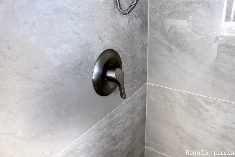 This Mississauga bathroom renovation presents an overall view of the shower area, featuring a glass enclosure and tiled walls. The layout emphasizes space efficiency, natural light, and a clean modern design suitable for everyday residential use.