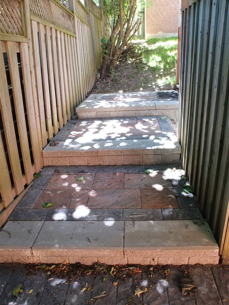 This Aurora interlocking renovation showcases professionally installed stone steps and side yard landscaping designed for durability and safety. The elevated interlock platform creates a smooth transition between levels, while the clean stone borders provide structural support and a refined finish.

Reno Compass Inc. carefully integrated proper grading and drainage to ensure long-term stability. The result is a functional and visually cohesive walkway that enhances accessibility and maximizes usable outdoor space.