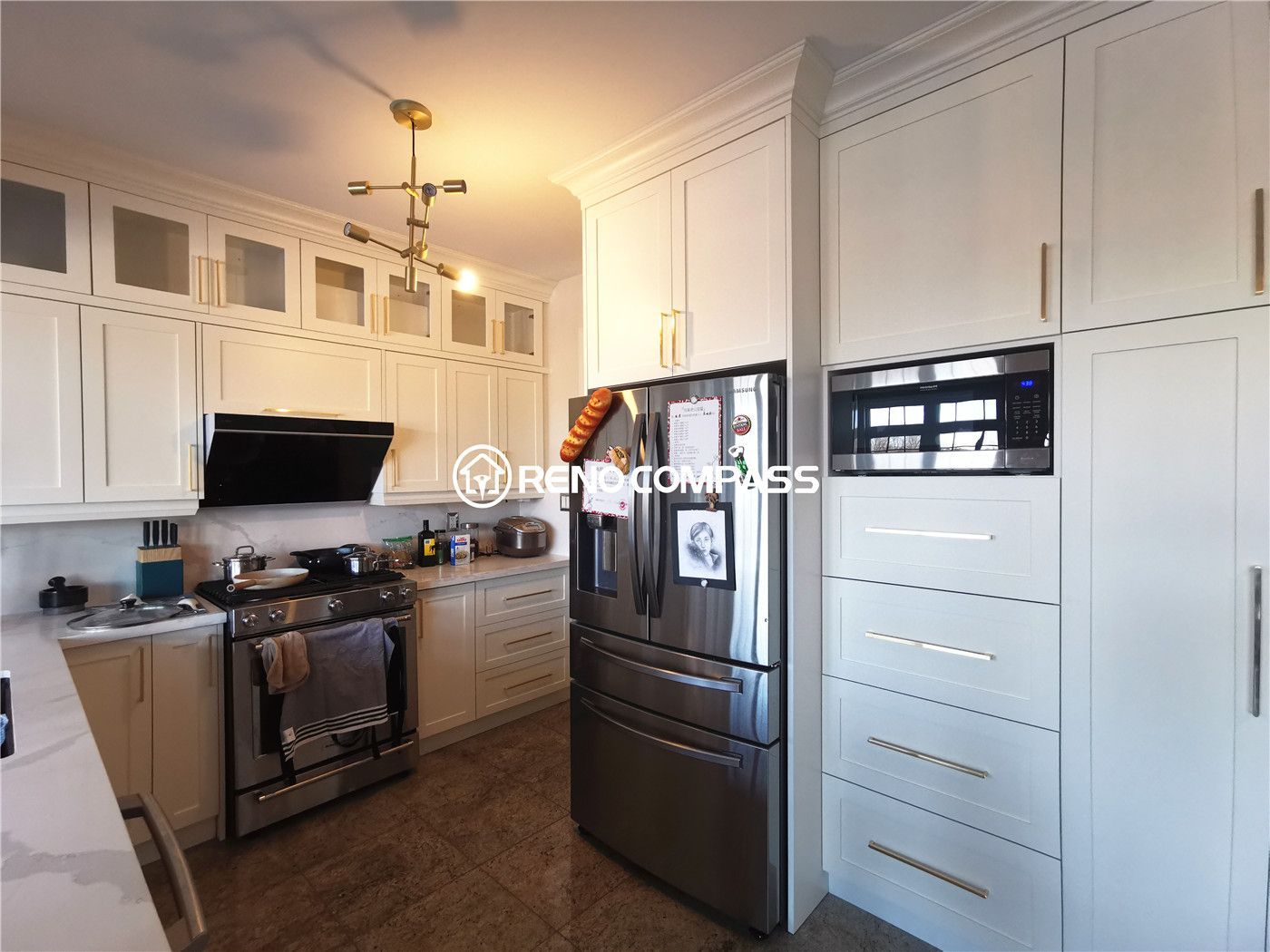 This King City kitchen renovation showcases a modern and functional layout featuring custom white cabinetry, quartz countertops, and premium stainless steel appliances. The spacious countertop area and upgraded sink with a contemporary faucet enhance daily usability, while the integrated dishwasher and professional-style range create a seamless cooking experience. Warm flooring tones and elegant hardware complete the cohesive design, delivering both comfort and sophistication. Designed and built by Reno Compass Inc., this kitchen transformation reflects quality craftsmanship and thoughtful space planning for modern family living.