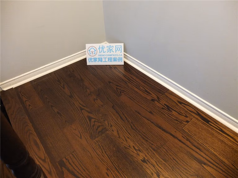 This close-up image showcases the rich natural wood grain of newly installed hardwood flooring in a Mississauga home renovation project. The flooring features deep brown tones, precise plank alignment, and clean baseboard finishes that create a refined and durable interior surface. As a professional Toronto Renovation Company, Reno Compass specializes in high-quality hardwood flooring installation that enhances both aesthetic appeal and long-term value for residential properties.